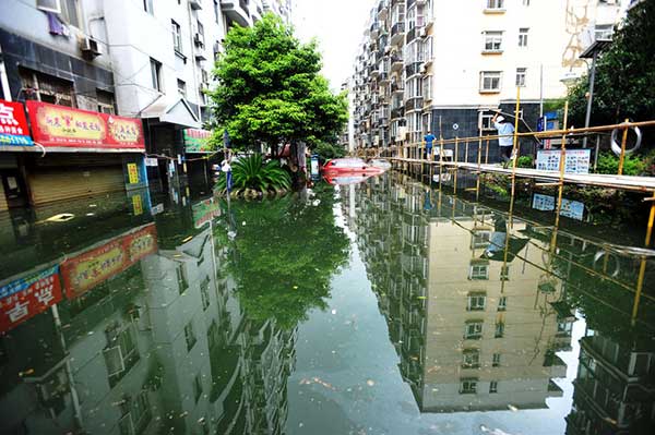 People walk on a 2,000-meter-long wooden platform built as a makeshift bridge at a residential community in Wuhan on July 11, 2016. Rising waters inundated the city and the flooding inconvenienced residents. (Photo/youth.cn) People walk on a 2,000-meter-long wooden platform built as a makeshift bridge at a residential community in Wuhan on July 11, 2016. Rising waters inundated the city and the flooding inconvenienced residents. (Photo/youth.cn)