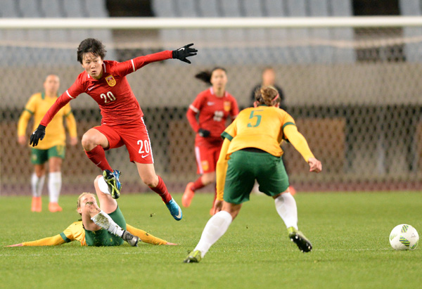China's Zhuang Rui (top) makes a pass during a round robin game against Australia during the Rio Olympics football qualifying tournament in Osaka, Japan, March 9, 2016. (Photo/Xinhua)