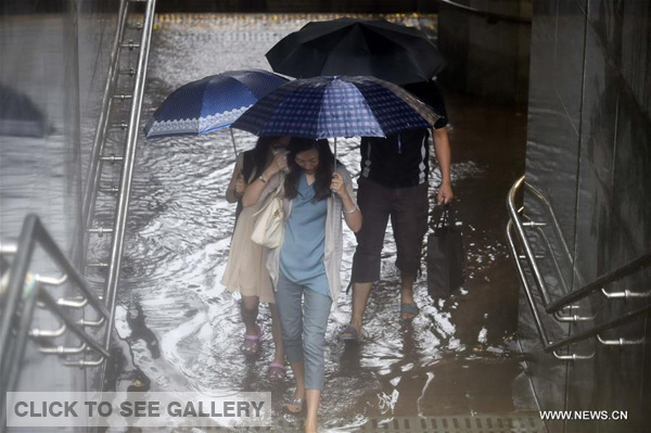 People walk past a flooded underground passage in Beijing, capital of China, July 20, 2016. Beijing's meteorological bureau issued an orange alert for rainstorm Wednesday noon. (Xinhua/Chen Yehua)