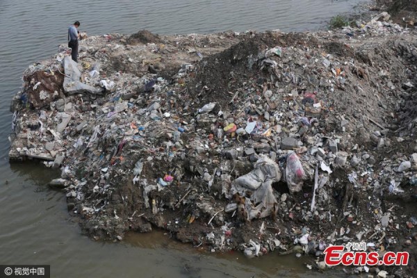 Garbage piles up near a bridge in Haimen City, East China's Jiangsu Province, July 17, 2016. The garbage, mainly decoration waste, was transported from Shanghai and dumped at the site illegally, sources say. (Photo/CFP)