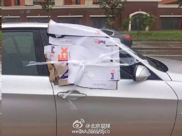 An anonymous passer-by pasted papers on an open car window in Beijing on Wednesday. A line on the paper reminds the "forgetful" driver says "Don't forget to close the window." (Photo/Sina Weibo)