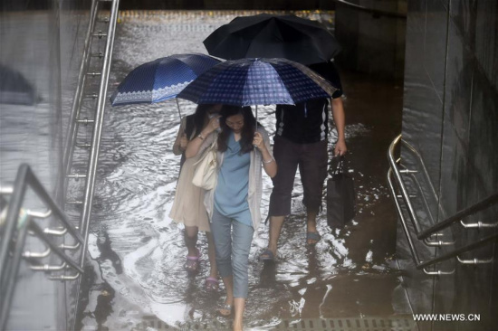 People walk past a flooded underground passage in Beijing, capital of China, July 20, 2016. Beijing's meteorological bureau issued an orange alert for rainstorm Wednesday noon. (Xinhua/Chen Yehua)