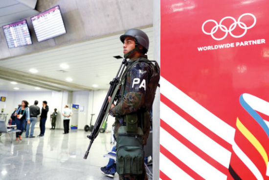 Armed police officers stand guard at Rio de Janeiro International Airport on Thursday night as security is tightened prior to the opening of the Olympic Games on Aug 5. (Photo/China News Service)