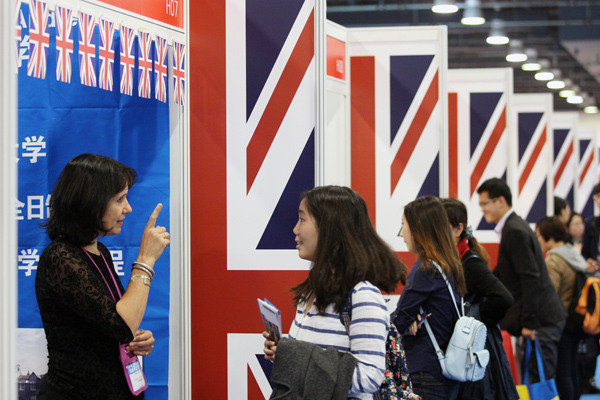 A British consultant talks with a visitor over the weekend at the 2015 China Education Expo in Beijing. (WANG ZHUANGFEI/ CHINA DAILY)