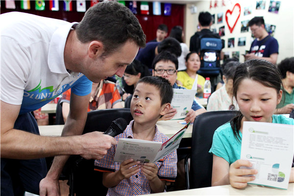 Timothy Clancy, an Australian student at Zhejiang University, teaches children English as he works as a volunteer for the upcoming G20 Summit in Hangzhou. Security rehearsals for the summit have been carried out between 11pm and 4am. ZHU XINGXIN / CHINA DAILY