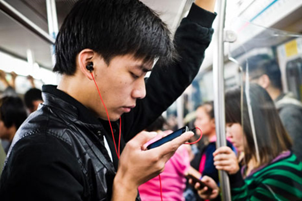A man plays with his smartphone on the Beijing subway, Nov 2012. (Photo/Xinhua)