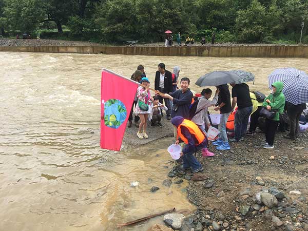 Volunteers pour fish larvae into Jinsha River in Southwest China's Yunnan province, July, 11, 2016.(Photo provided to chinadaily.com.cn)