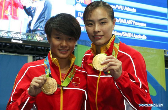 Chinese diving athletes Wu Minxia (R) and Shi Tingmao show gold medals at the awarding ceremony of women's SYNC.3M Springboard in Rio de Janeiro, Brazil, on Aug. 7, 2016. Wu Minxia and Shi Tingmao won the gold medal with 345.60. (Xinhua/Cao Can) 