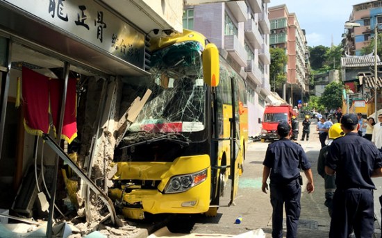 A bus and a storefront are heavily damaged after the vehicle rolled downhill on Monday in Macao. Photo/Xinhua