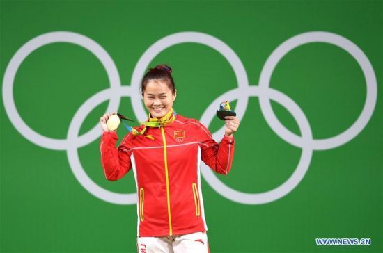 Deng Wei of China celebrates at the awarding ceremony of the women's 63KG weightlifting group A final at the 2016 Rio Olympic Games in Rio de Janeiro, Brazil, on Aug. 9, 2016. Deng Wei won gold medal with clean and jerk, total world records. (Xinhua/Cheng Min)
