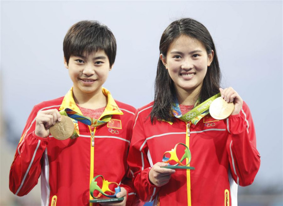 Chen Ruolin (R) and Liu Huixia of China attend the awarding ceremony of women's synchronised 10m platform diving at the 2016 Rio Olympic Games in Rio de Janeiro, Brazil, on Aug. 9, 2016. Chen Ruolin and Liu Huixia won the gold medal. (Xinhua/Fei Maohua)