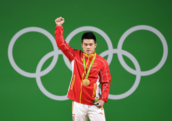 Shi Zhiyong of China celebrates at the awarding ceremony of the men's 69KG weightlifting group A final at the 2016 Rio Olympic Games in Rio de Janeiro, Brazil, on Aug. 9, 2016. Shi Zhiyong won the gold medal with 352KG. (Xinhua/Cheng Min)