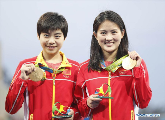 Chen Ruolin (R) and Liu Huixia of China attend the awarding ceremony of women's synchronised 10m platform diving at the 2016 Rio Olympic Games in Rio de Janeiro, Brazil, on Aug. 9, 2016. Chen Ruolin and Liu Huixia won the gold medal. (Xinhua/Fei Maohua) 
