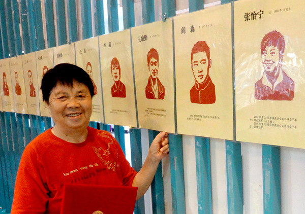 Deng Rongrong with her latest cut-paper album at Xiamen Olympic Museum in Fujian province. (Photo/CHINA DAILY)