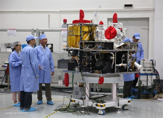 Deputy chief engineer Zhou Yilin (3rd L) discusses with other technicians beside the quantum satellite at Shanghai Engineering Center for Microsatellites, under the Chinese Academy of Sciences, in Shanghai, east China, May 25, 2016. (Xinhua/Cai Yang)