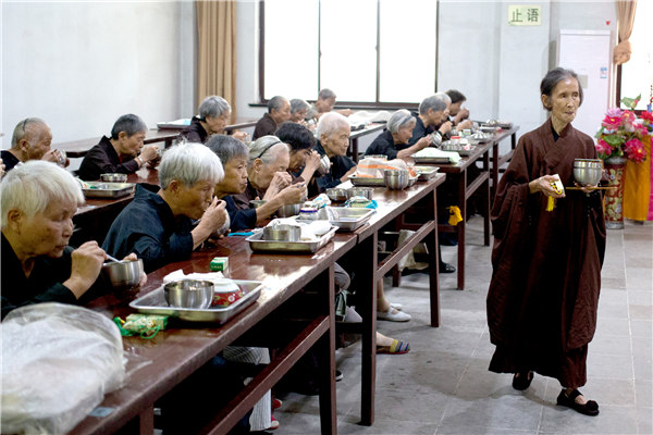 Seniors eat lunch in the dining room at the Lingyanshan Buddhist Nursing Home. PHOTOS BY GAO ERQIANG / CHINA DAILY