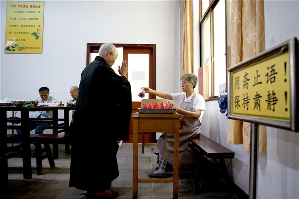 A resident collects a portion of fruit after lunch at the home. PHOTOS BY GAO ERQIANG / CHINA DAILY