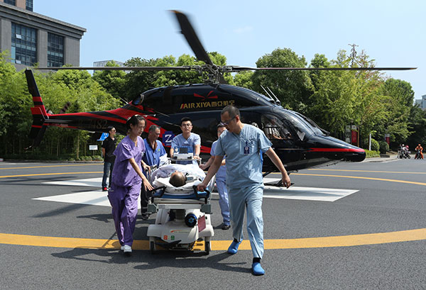 Emergency medical workers transfer a heart attack patient from a helicopter to a hospital in Hangzhou, Zhejiang province, on Sunday. Currently 11 helicopters provide transfer services for a new hospital network.(Photo provided to China Daily)