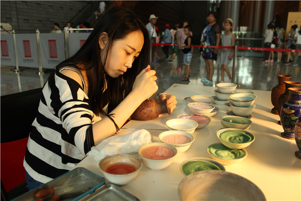A young artisan works on a piece of cloisonne enamel at the opening of Eight Marvelous Handicrafts of Beijing. The exhibition that runs through Nov 9 showcases the best of the city's traditional craftsmanship. WANG KAIHAO/CHINA DAILY