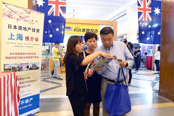 A couple look at a property brochure recommended by a sales agent at a property fair in Shanghai. (Provided to China Daily)