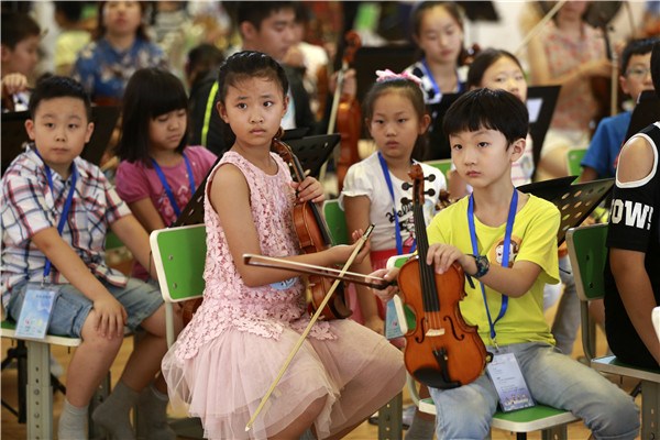 Children practice different musical instruments during a 10-day music camp in Beijing. The non-professionals will give a performance at the Beijing Concert Hall on Monday. FENG YONGBIN/CHINA DAILY