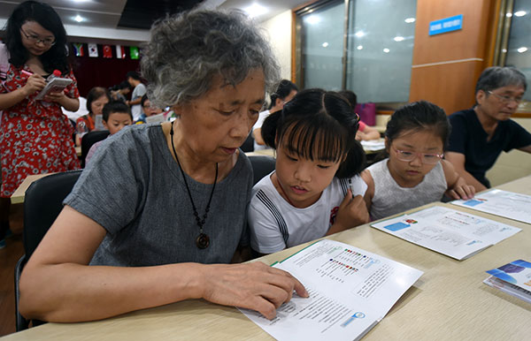 Lin Meiru, a 67-year-old resident of Hangzhou, studies English with her 12-year-old granddaughter Ling Jing at a community class in the city. Many of the locals are learning English to welcome the G20. Wang Dingchang / Xinhua