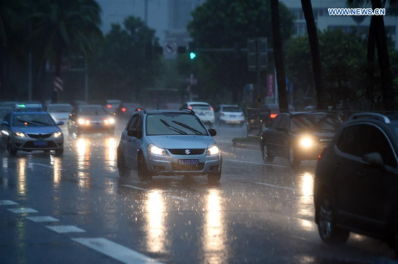 Cars drive on a road in Haikou, capital of south China's Hainan Province, Aug. 18, 2016. Hainan was affected by typhoon Dianmu, the eighth of the season, with many regions greeting heavy rainfall. (Photo: Xinhua/Yang Guanyu)
