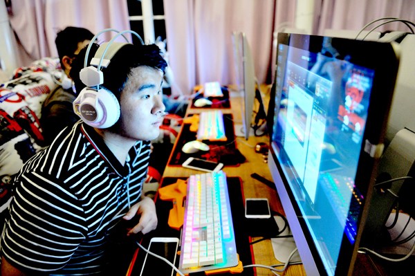 A college student plays video games at an e-sports bar during his summer vacation in Qingdao, Shandong province. Yu Fangping / For China Daily