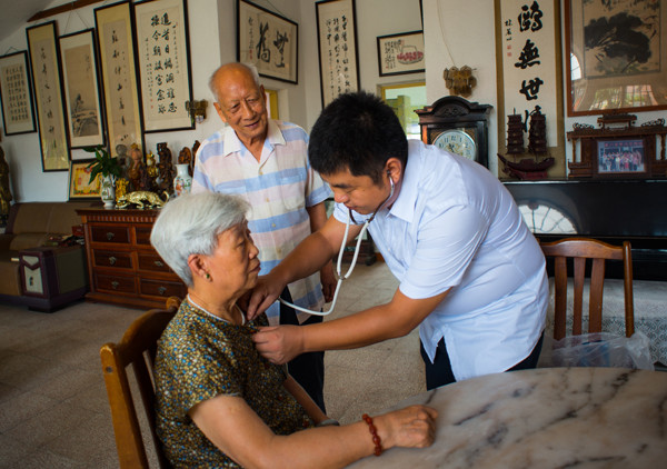 A hospital doctor provides hospital-to-home service for community residents in Xiamen, Fujian province. (PAN SONGGANG/FOR CHINA DAILY)