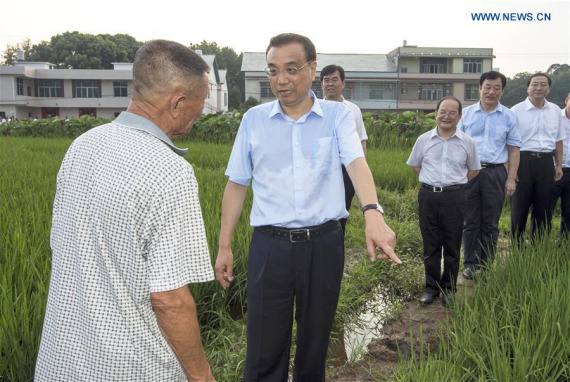 Chinese Premier Li Keqiang talks with a farmer in a paddy field on his way to Ruijin, east China's Jiangxi Province, Aug. 22, 2016. Li made an inspection tour in Jiangxi from Aug. 22 to 24. (Photo: Xinhua/Xie Huanchi)