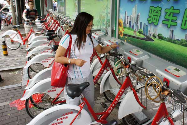 A woman rents a bicycle in the Sanyuanqiao area. Beijing now offers 14,000 bikes for rent and plans to nearly double the number this year to promote eco-friendly transportation. Provided to China Daily