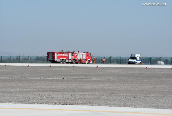Fire engines and an ambulance are seen at the accident site after an acrobatic plane plummeted to the ground during the 1st Silk Road International General Aviation Convention in Zhangye, northwest China's Gansu Province, Aug. 27, 2016. The pilot of the acrobatic plane was killed. (Xinhua/Fan Peishen)