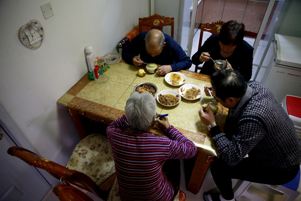 Three volunteers give Ye Sufen, a 83-year-old who lives alone, a haircut at her home in Jinzhou, Liaoning province. (Photo by LI TIECHENG/CHINA DAILY)