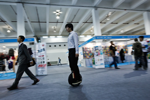 A visitor tries out an electric self-balancing scooter during an event at the Shanghai International Exhibition Center. (Photo/provided to China Daily)