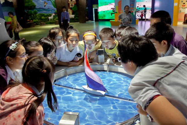 Children learn about wind power by watching a simulated sailing ship movement at the Hangzhou Low Carbon Science and Technology Museum. (Photo provided to China Daily)