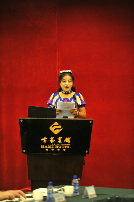 A representative of the local embroiderers shares her experiences with the attendees at the meeting, Hami, Xinjiang, Aug 18, 2016. (Photo provided to chinadaily.com.cn)