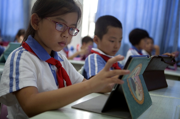 Students use iPads during a class at Houhai Primary School in Beijing. (Huo Jianbin / For China Daily)