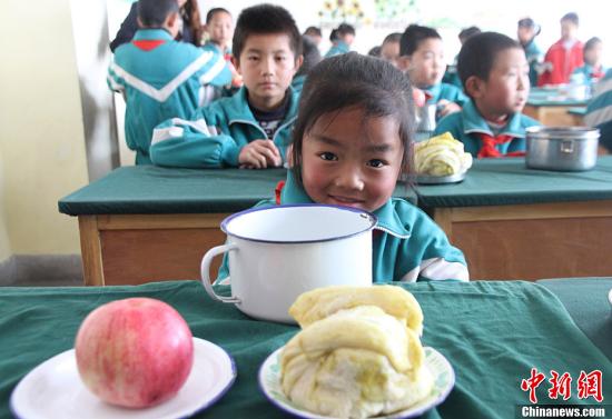 A pupil having her breakfast in a primary school in northwest China's Gansu province (Photo: Chinanews.com/Zhang Daozheng)