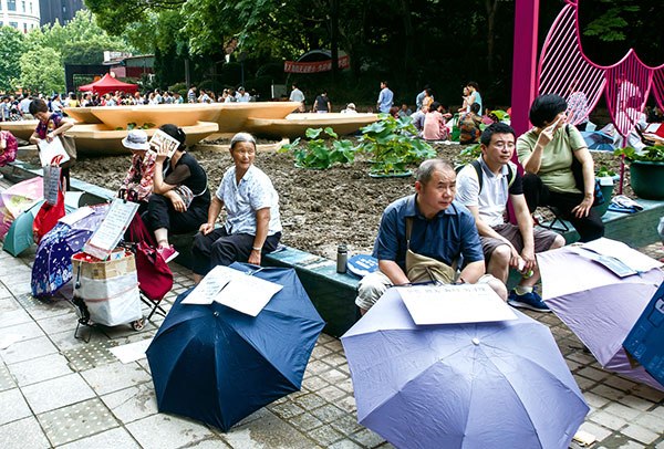 Parents place umbrellas, each carrying sheets of paper containing information about their unmarried children, at the matchmaking market in People's Park in downtown Shanghai last month.(Photo by GAO ERQIANG/CHINA DAILY)