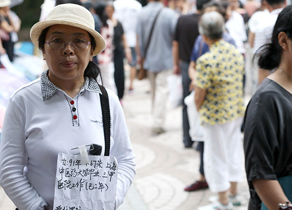 A woman holds a sheet of paper carrying information about her daughter at the park. (Photo by WANG YADONG/CHINA DAILY)