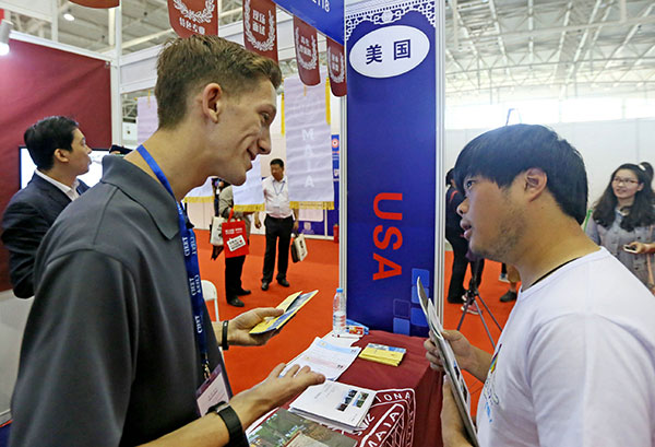 A university official from the US introduces his school during an international education expo in Beijing in May. (Photo/China Daily)