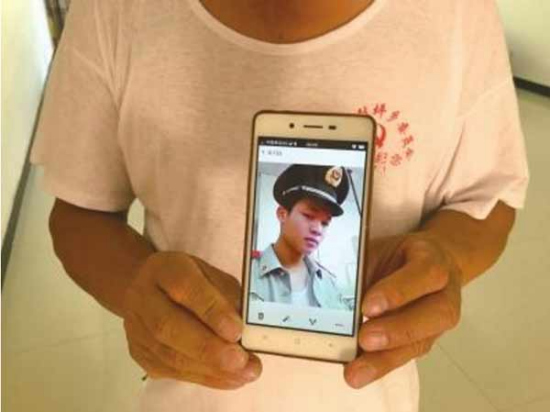 Father Cai Laiyuan holds the photo of his deceased son Cai Jiayuan. (Photo: Beijing Times/Fan Rui)