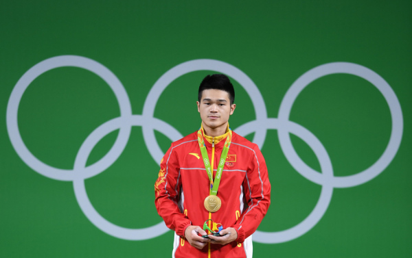 Shi Zhiyong of China lifts gold during the men's 69kg category of the Rio 2016 Olympic Games Weightlifting events at the Riocentro in Rio de Janeiro, Brazil, Aug 9, 2016.(Photo/Xinhua)