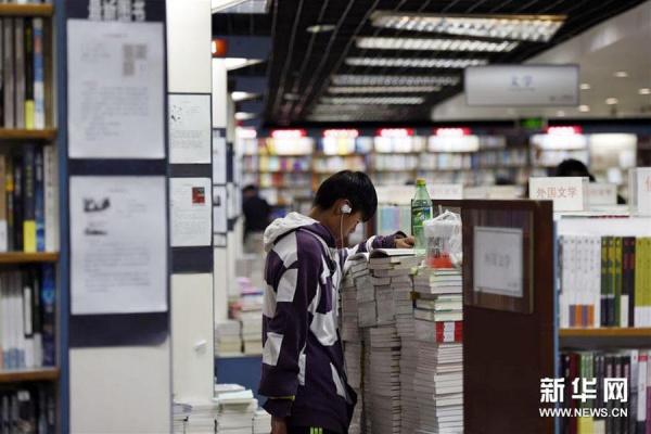 A 16-year-old surnamed Zhang reads a book at the 24-hour Sanlian Taofen Bookstore at 9:43 p.m. in Beijing on April 18, 2016. Zhang said he lives near the bookstore and has been coming to the store every night for more than two weeks.(Photo/Xinhua)