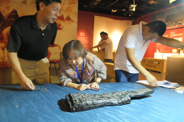Archaeologists examine a musical instrument made of lacquer more than 2,000 years ago in the Jinsha Site Museum in Chengdu, Sichuan province. It will open to visitors in the museum from August 20 to October 31.(Photo by Huang Zhiling/chinadaily.com.cn) Archaeologists examine a musical instrument made of lacquer more than 2,000 years ago in the Jinsha Site Museum in Chengdu, Sichuan province. It will open to visitors in the museum from August 20 to October 31.(Photo by Huang Zhiling/chinadaily.com.cn)