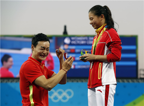 Chinese diver Qin Kai gets a yes after proposal to his girlfriend, He Zi, at the Rio Olympics after the medal ceremony for the women's 3m springboard, Aug 14, 2016. (Photo/Xinhua)