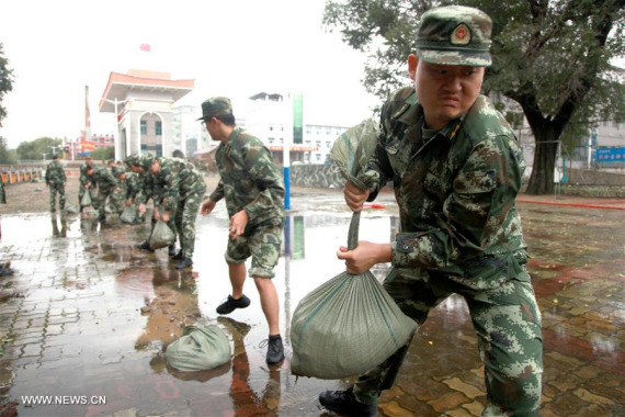 Border guards pass sand bags to reinforce flood defences along the Tumen River, a cross-border river, in northeast China's Jilin Province, Aug. 31, 2016. (Photo: Xinhua/Zhang Biao)