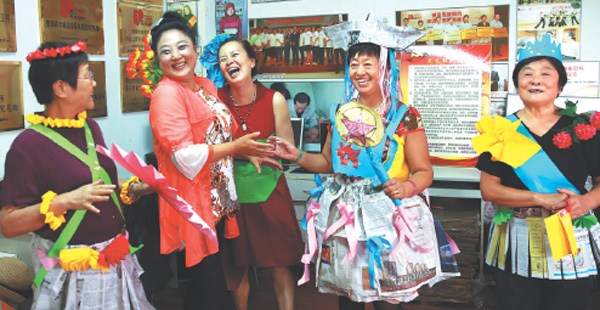 Xu Kun (second from left) plays a game with elderly residents at the Beijing office of Love Elderly Hotline that she founded a decade ago to provide psychological counseling service to seniors. (Photo by Zou Hong/China Daily)
