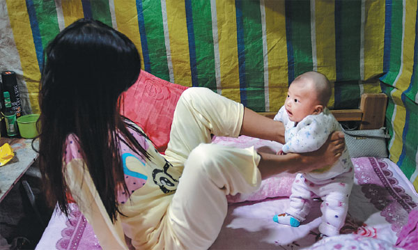 Xiang Liping plays with her child at her home in Shantou, Guangdong province. Photos By Chen Yongheng / For China Daily