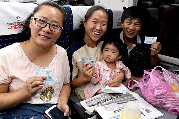 Passengers show their tickets on the inaugural run of the Zhengzhou-Xuzhou high-speed railway in Zhengzhou, Henan province, on Saturday. (Photo/Xinhua)